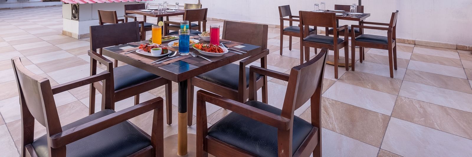 Rooftop dining with tables and chairs under umbrellas at DLS The Classio